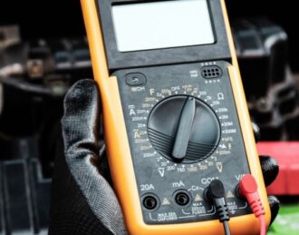 Technician using a diagnostic scanner to test a car's electrical system at Eccles Auto Service in Hamilton, ON